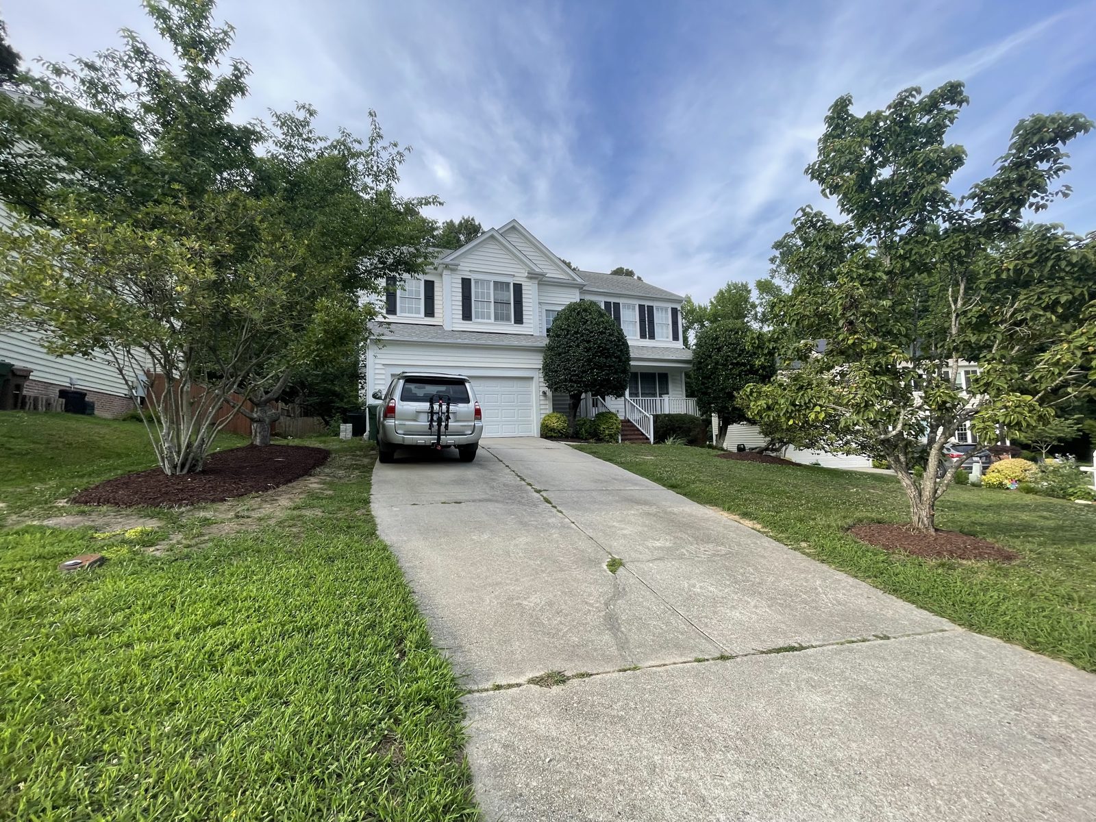Front yard lawn maintenance with freshly cut grass and new mulch beds around the trees