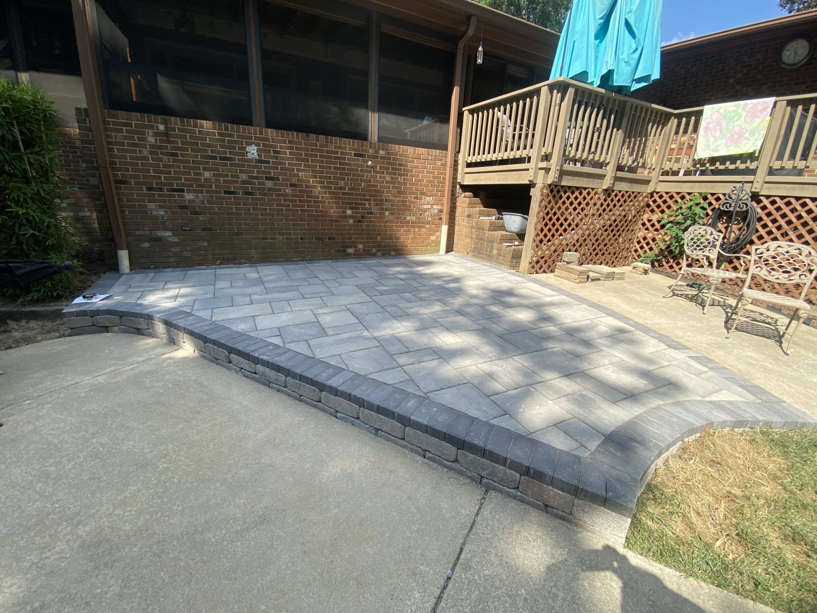 Herringbone paver patio off a raised deck