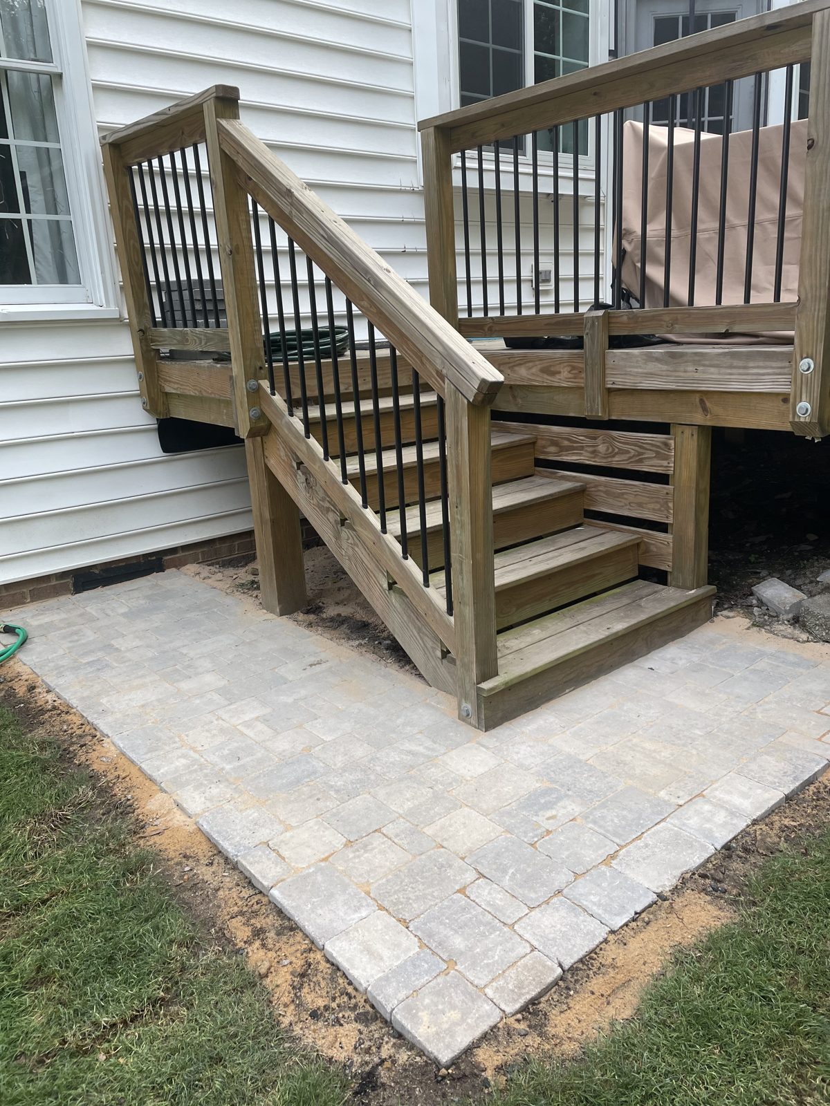 Paver patio laid at the base of the deck steps