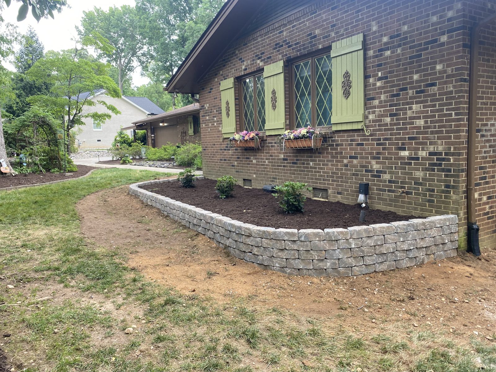 Stone retaining wall with a fresh planting bed